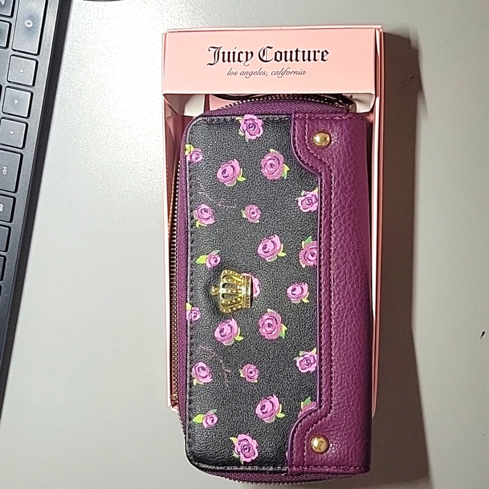 Juicy Couture Black wallet with purple zip around trim and purple flowers.